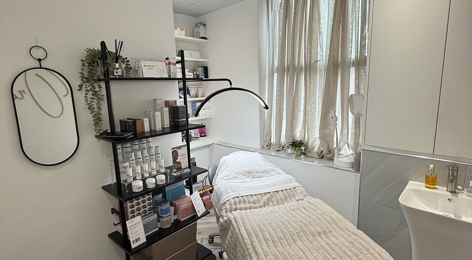 Relaxing treatment room at Skin Orchid, London, England, GB with a cozy bed and beauty products.