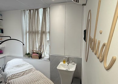 Cozy treatment room at Skin Orchid, London, England, GB with a bed, sink, and soft lighting.