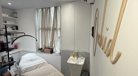 Cozy treatment room at Skin Orchid, London, England, GB with a bed, sink, and soft lighting.