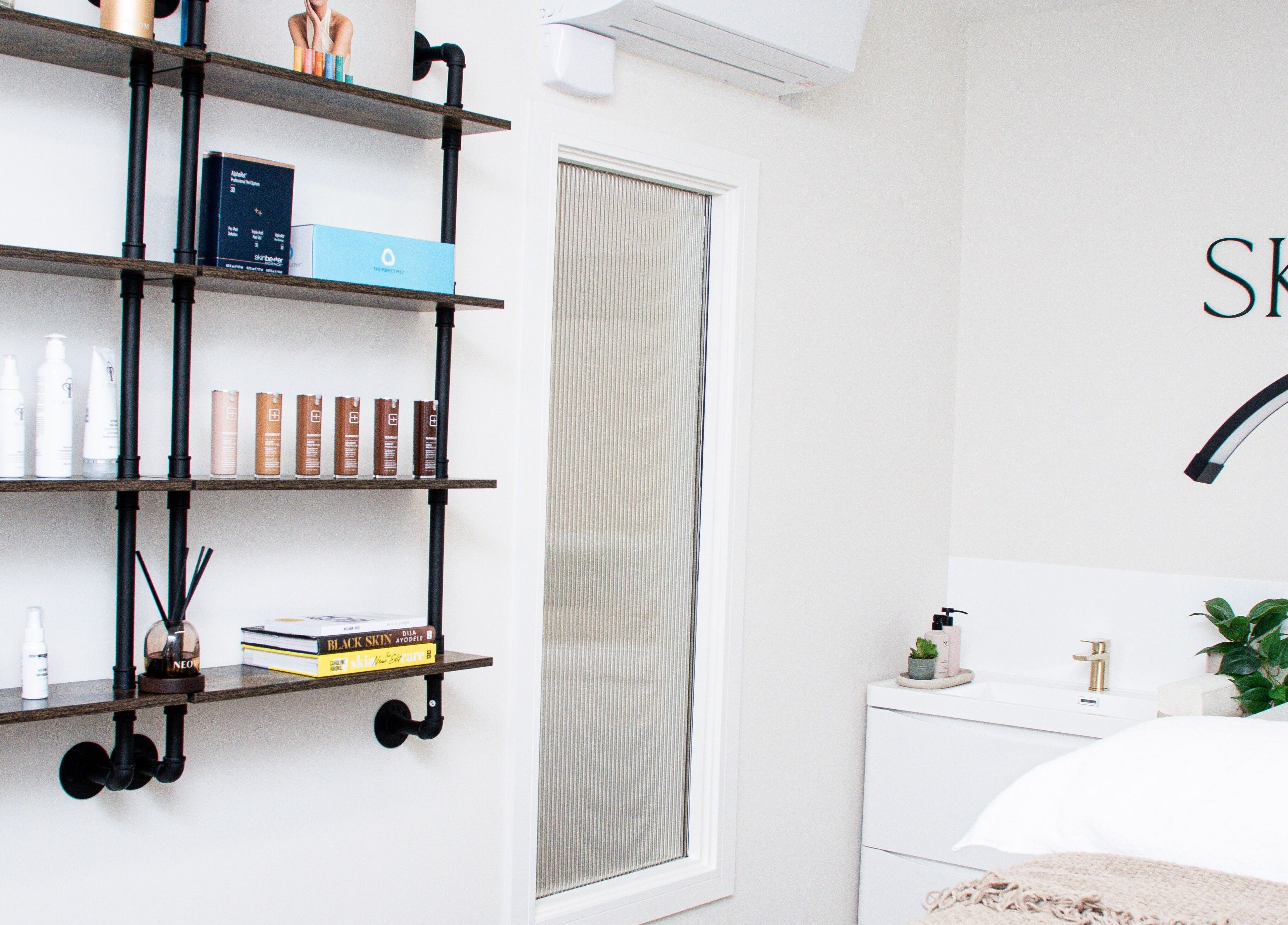 Modern skincare shelves and cozy treatment bed at Skin Orchid, London, England, GB.