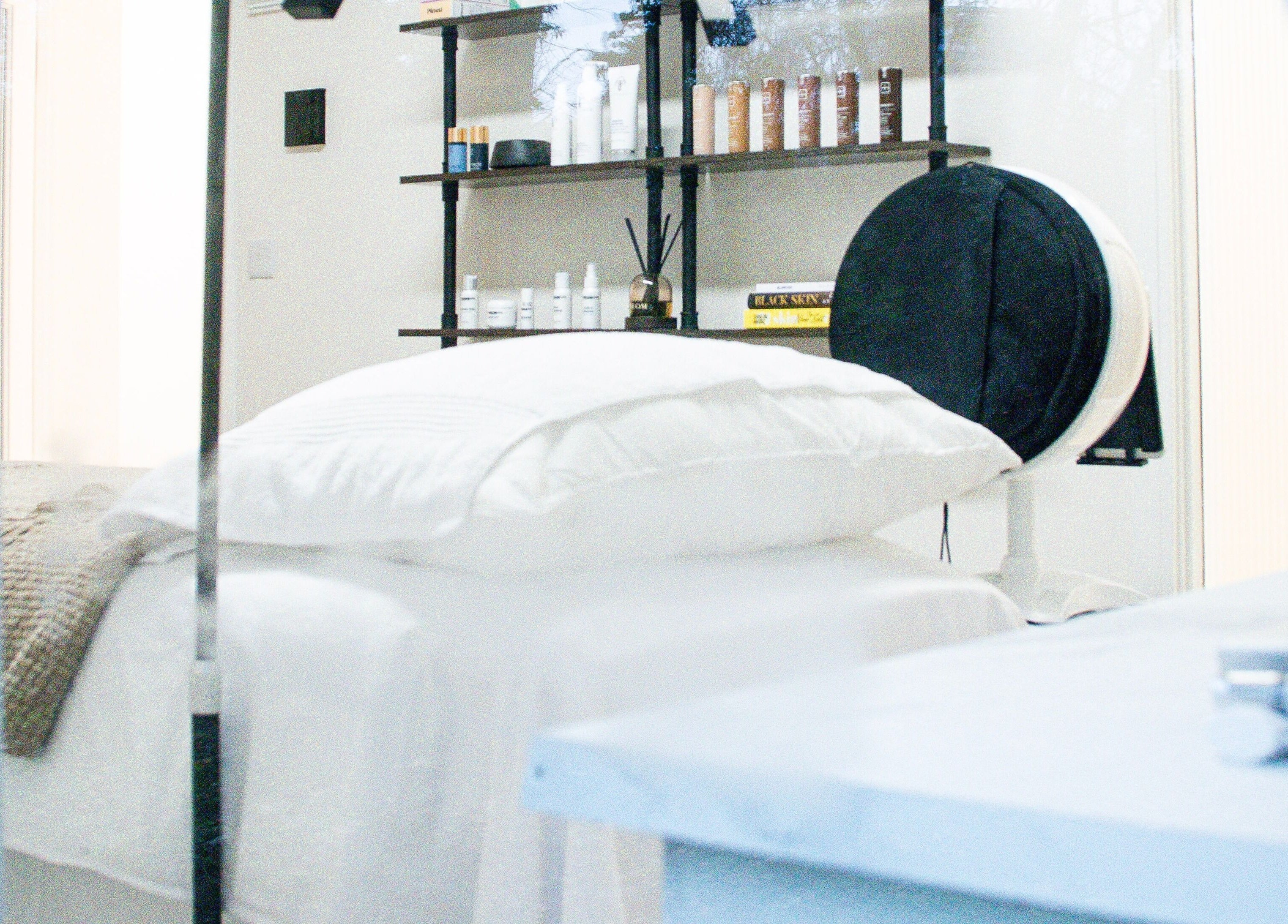 Tranquil treatment room at Skin Orchid, London, England, GB with a cozy bed and elegant product display.