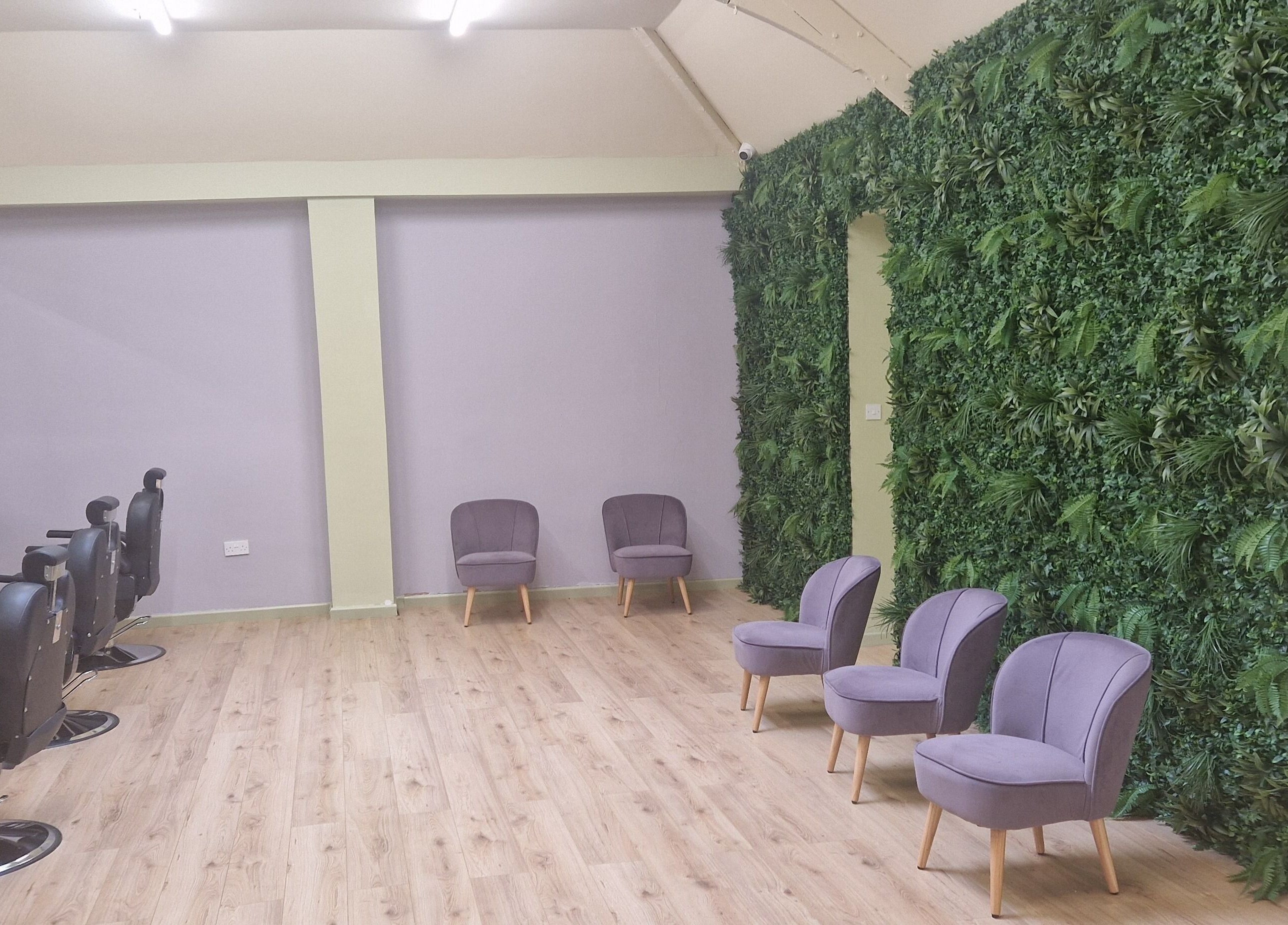 Elegant interior of Lia Brow Bar in Newcastle upon Tyne, England, featuring lush green walls and modern seating.