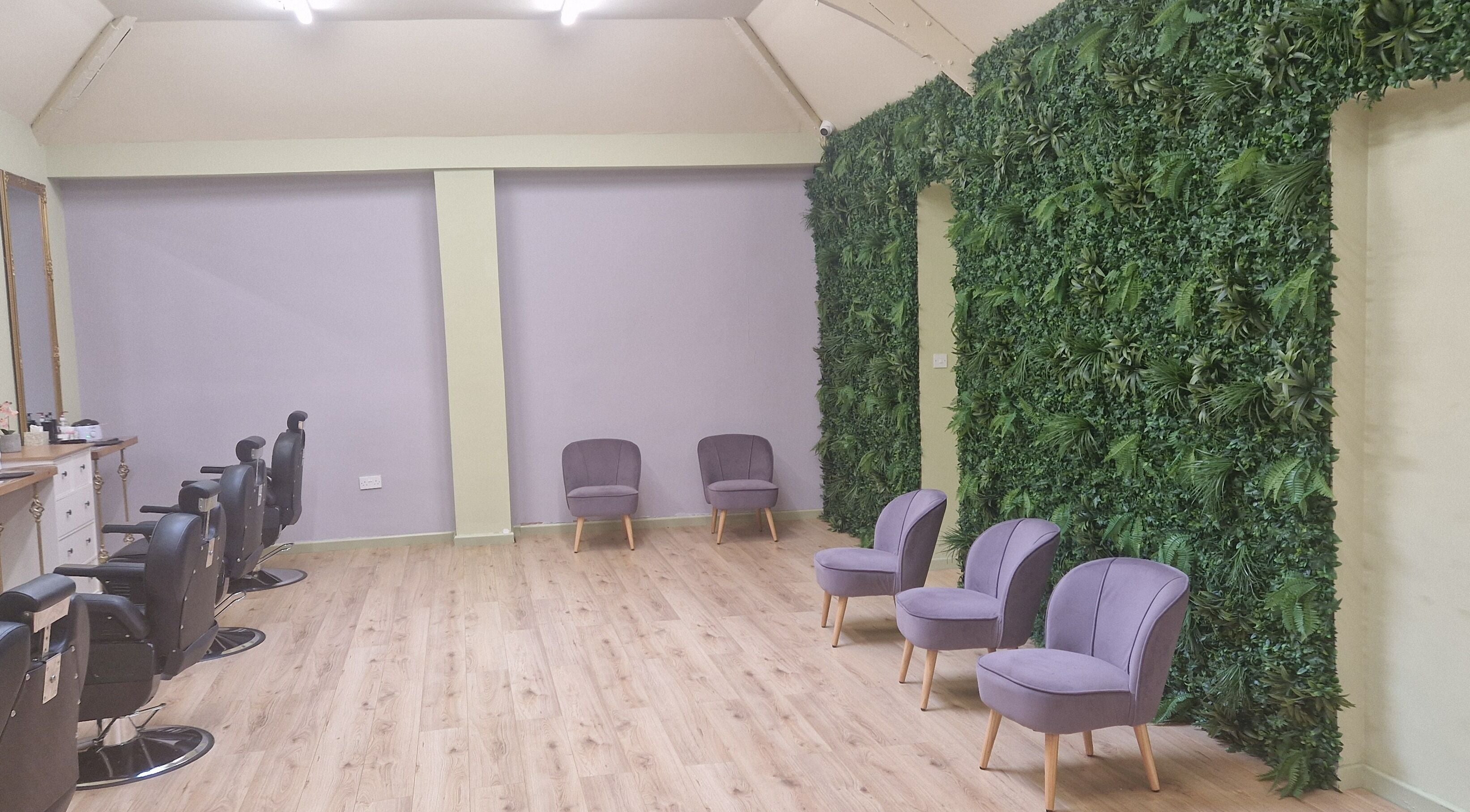 Elegant interior of Lia Brow Bar in Newcastle upon Tyne, England, featuring lush green walls and modern seating.