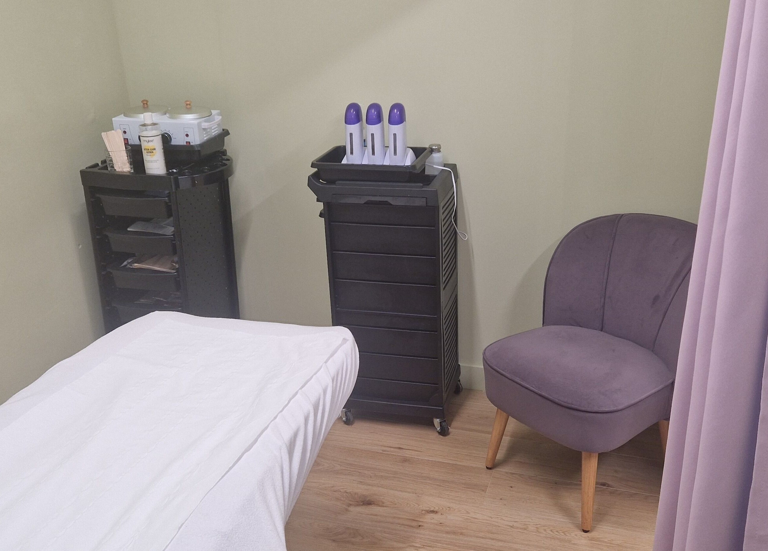 Private treatment room at Lia Brow Bar, Newcastle upon Tyne, England, GB, featuring a treatment bed and elegant seating.