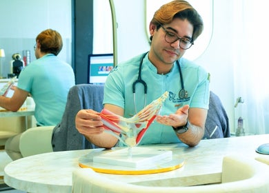 Profissional do Dr. Foot & Ankle, em Londres, analisando modelo anatômico do pé.