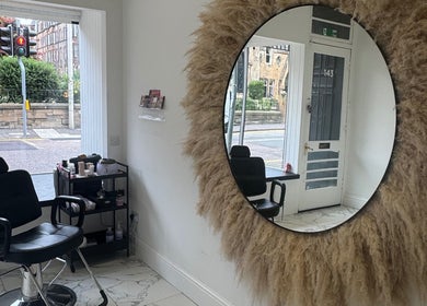 Chic interior of The Brow & Lash Lab ByElle in Edinburgh, Scotland, GB with a decorative mirror and salon chair.