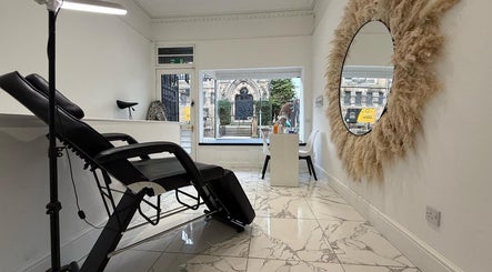 Modern beauty treatment room at The Brow & Lash Lab By Elle, Edinburgh, Scotland, GB, with chic decor and comfy chairs.