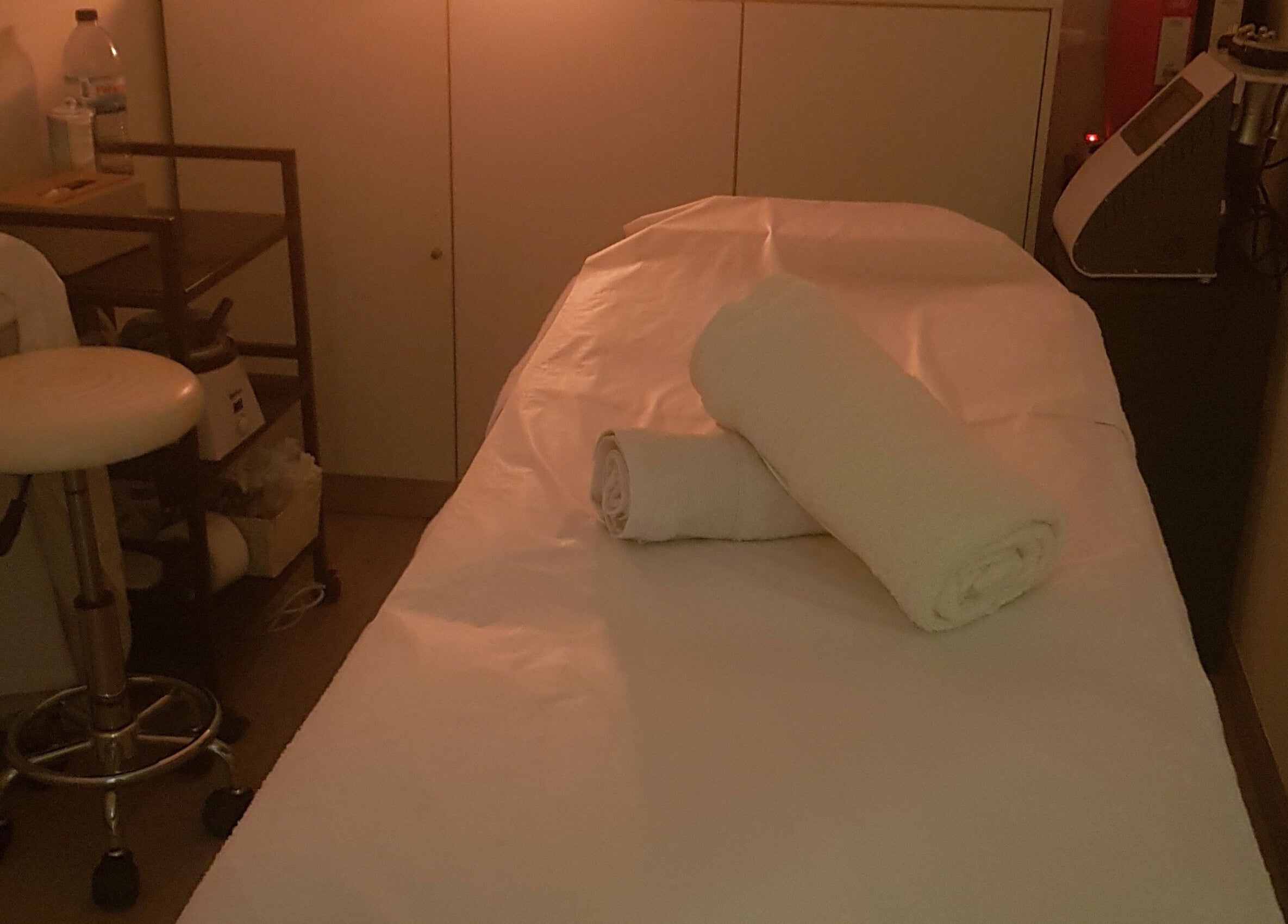 Sala de massagem acolhedora no ButterFlySpa, Caldelas, Braga, PT, com mesa de massagem e toalhas.