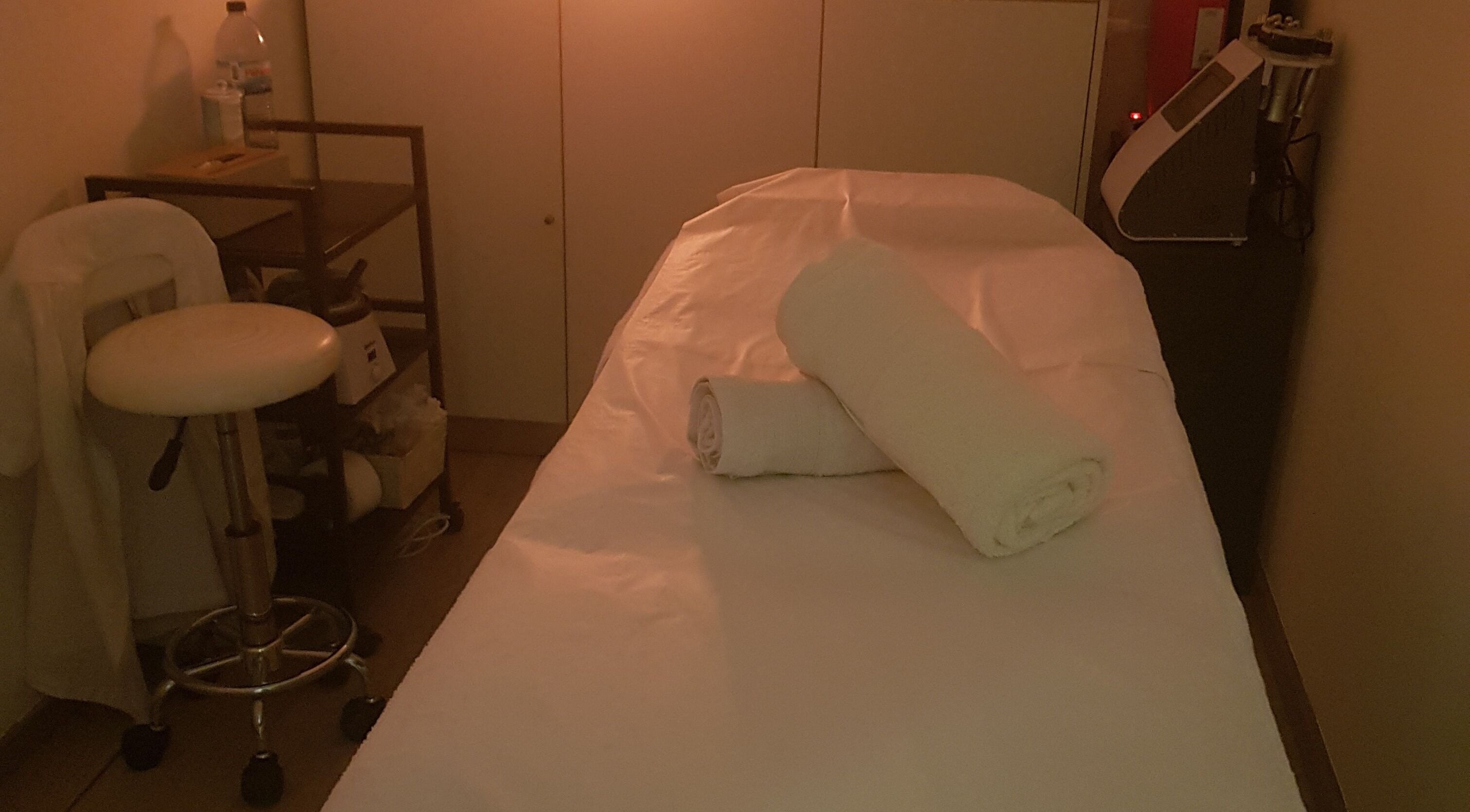 Sala de massagem acolhedora no ButterFlySpa, Caldelas, Braga, PT, com mesa de massagem e toalhas.