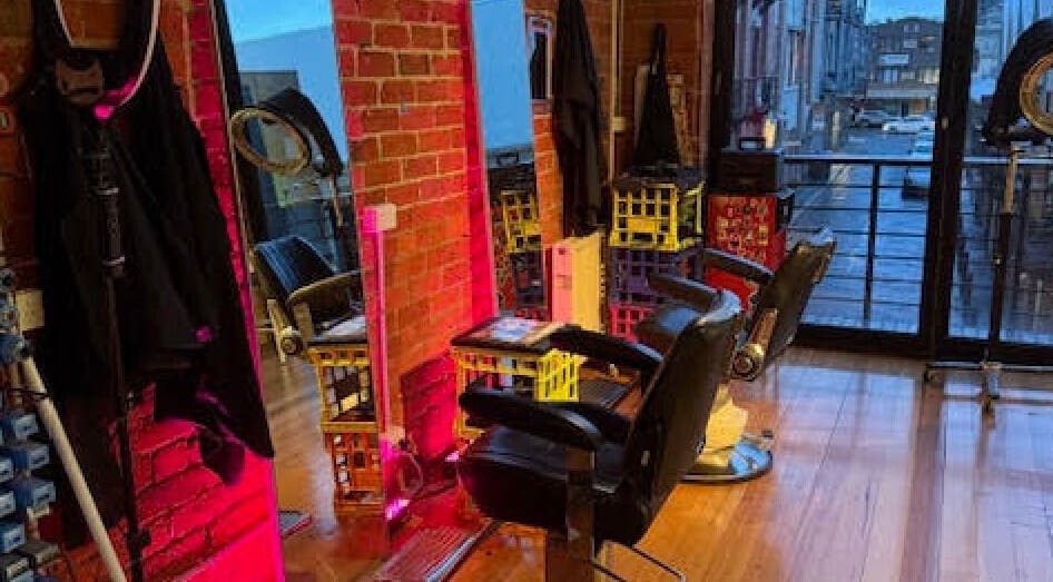Stylish interior of Hair Agenda in Prahran, Victoria, AU, showcasing modern salon chairs and vibrant lighting.