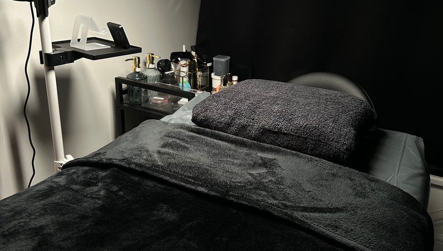 A cozy bed setup at Lash Me, Hounslow, England, GB with plush towels and ambient lighting for relaxation.