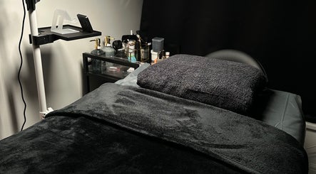 A cozy bed setup at Lash Me, Hounslow, England, GB with plush towels and ambient lighting for relaxation.