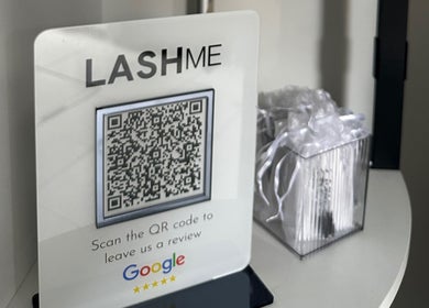 QR code for reviews at Lash Me in Hounslow, England, GB, displayed on a counter.
