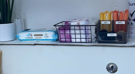 Beauty essentials on display at Lash Me, Hounslow, England, GB featuring wipes, tampons, and hair ties.