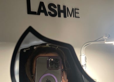 Reflection of a client in a mirror at Lash Me, Hounslow, England, GB, showcasing salon ambiance and branding.