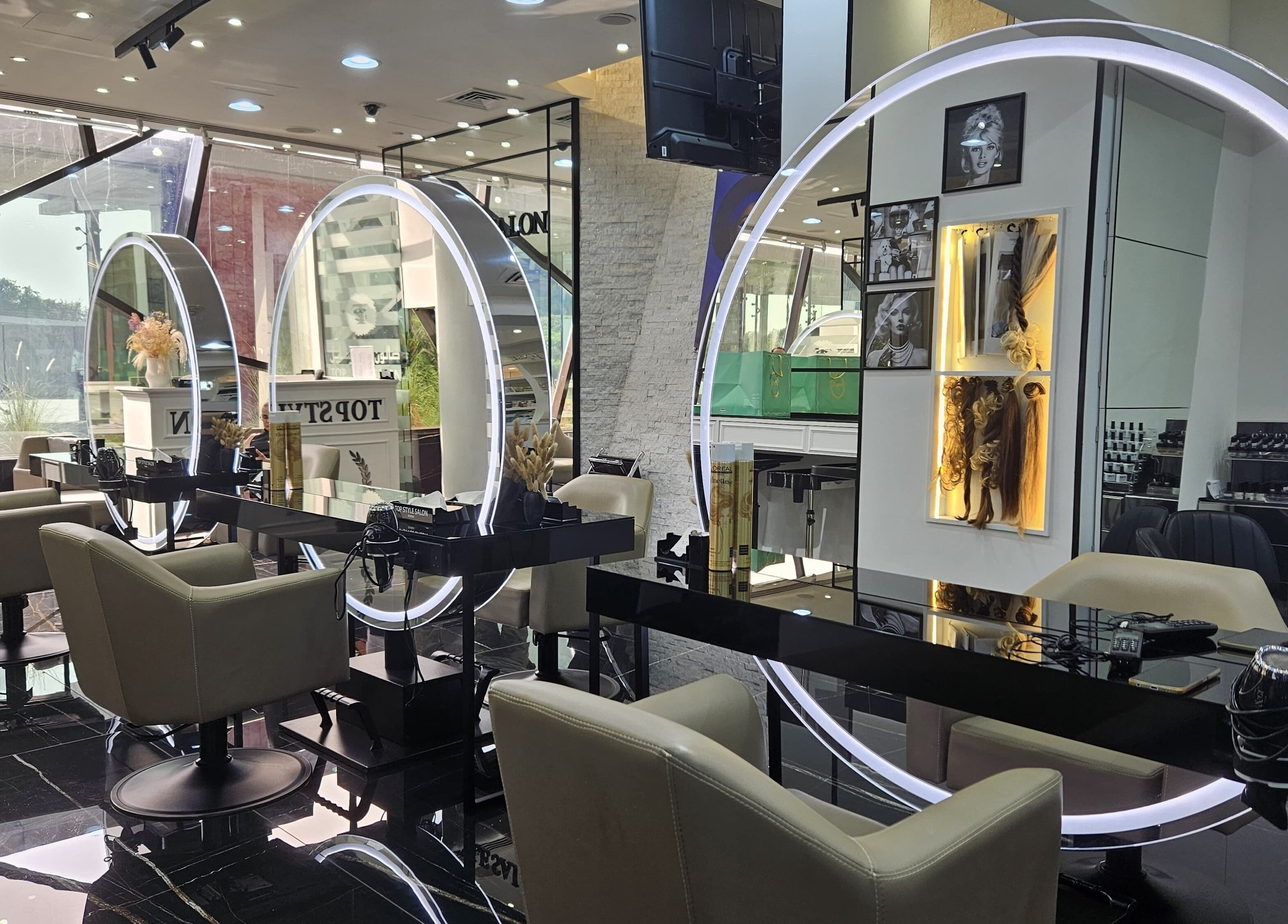 Modern styling stations at Top Style Ladies Saloon in Dubai, AE with sleek chairs and illuminated mirrors.