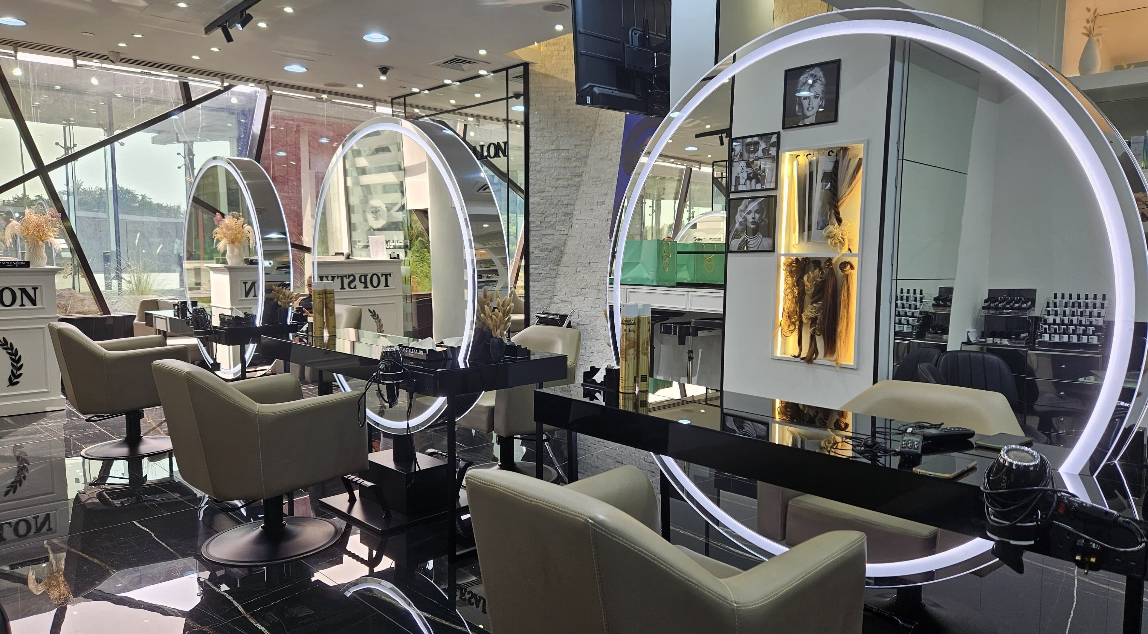 Modern styling stations at Top Style Ladies Saloon in Dubai, AE with sleek chairs and illuminated mirrors.