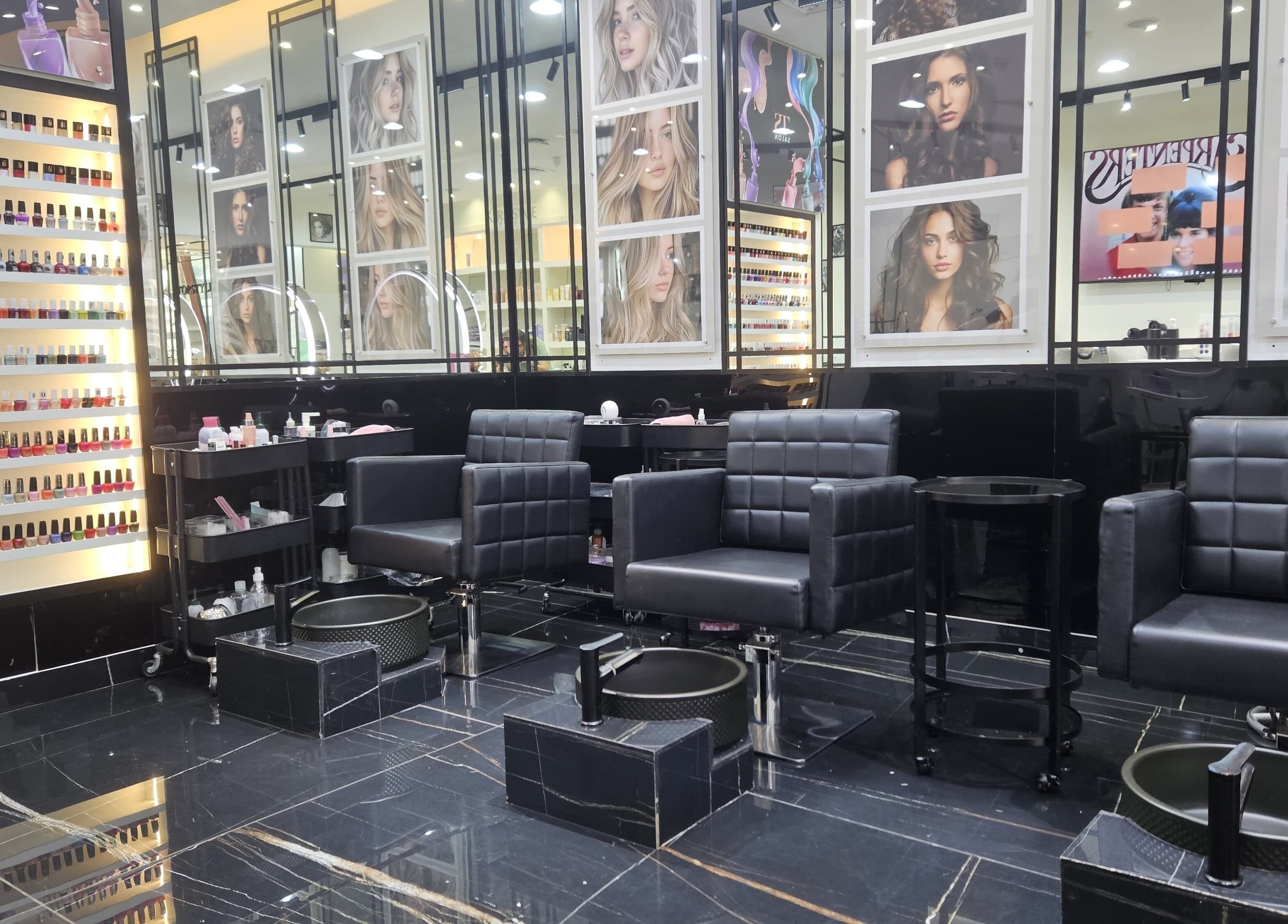 Chic manicure area at Top Style Ladies Saloon in Dubai, AE with sleek black chairs and vibrant nail polish display.