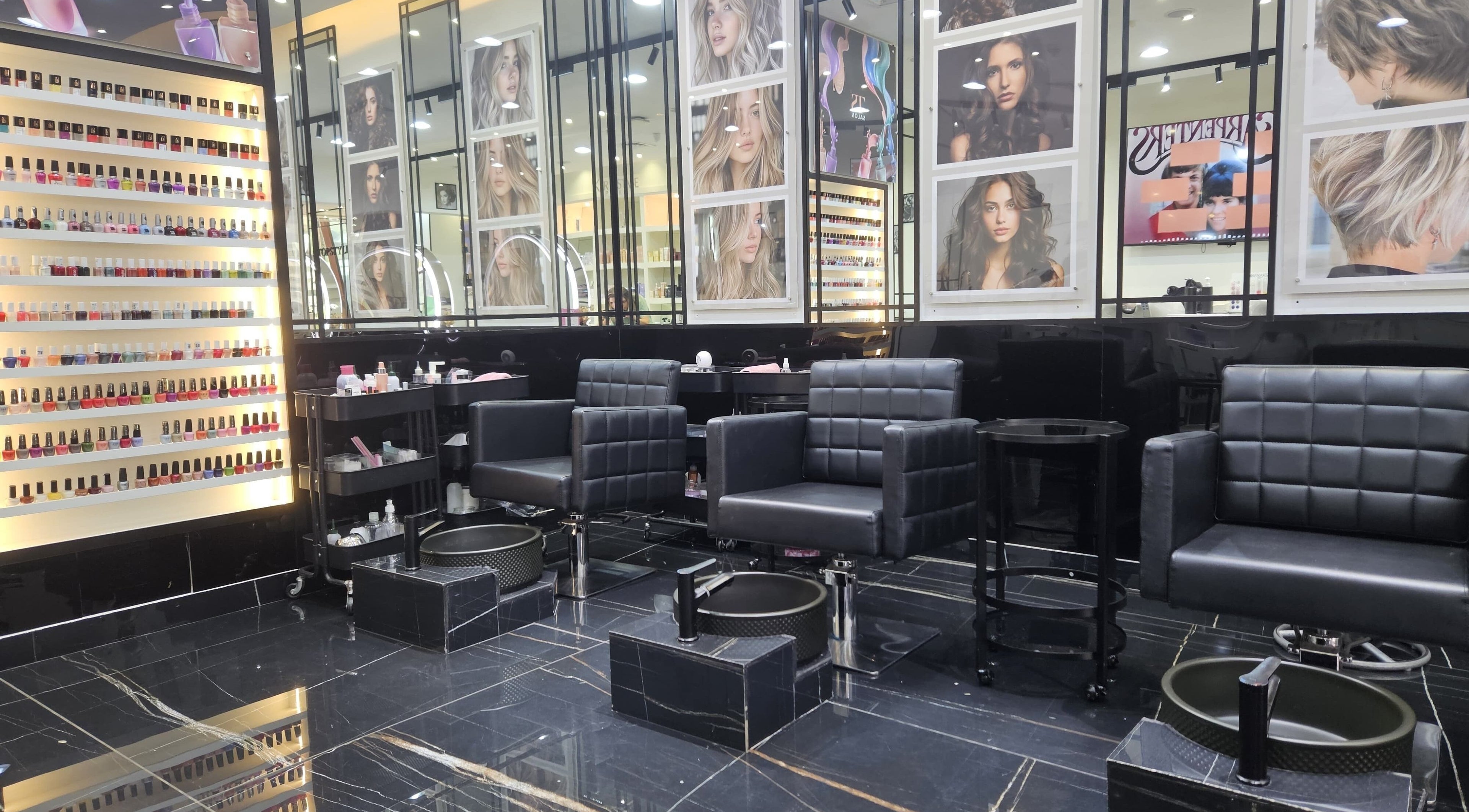 Chic manicure area at Top Style Ladies Saloon in Dubai, AE with sleek black chairs and vibrant nail polish display.