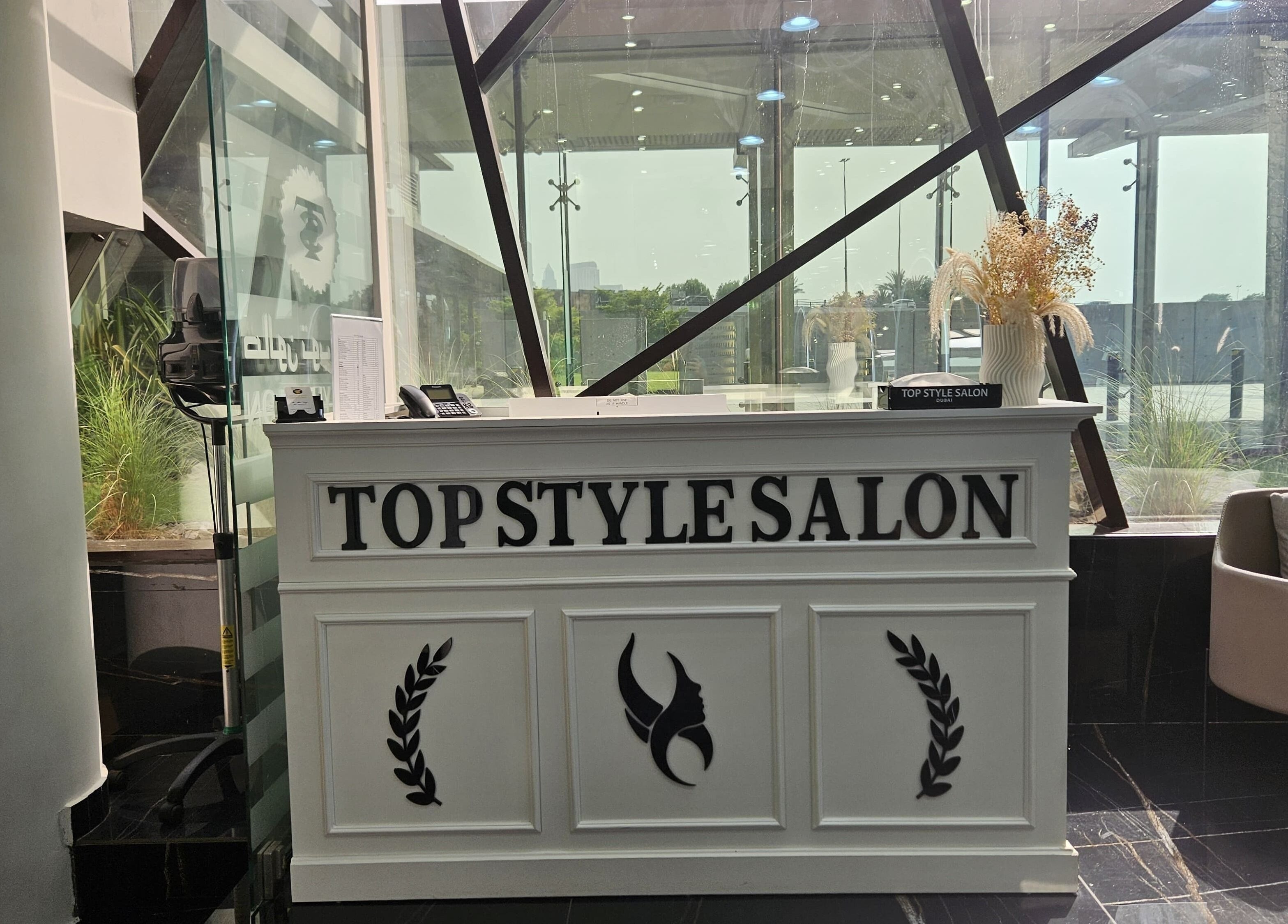 Stylish reception desk at Top Style Ladies Saloon, Dubai, AE with modern decor and seating area.