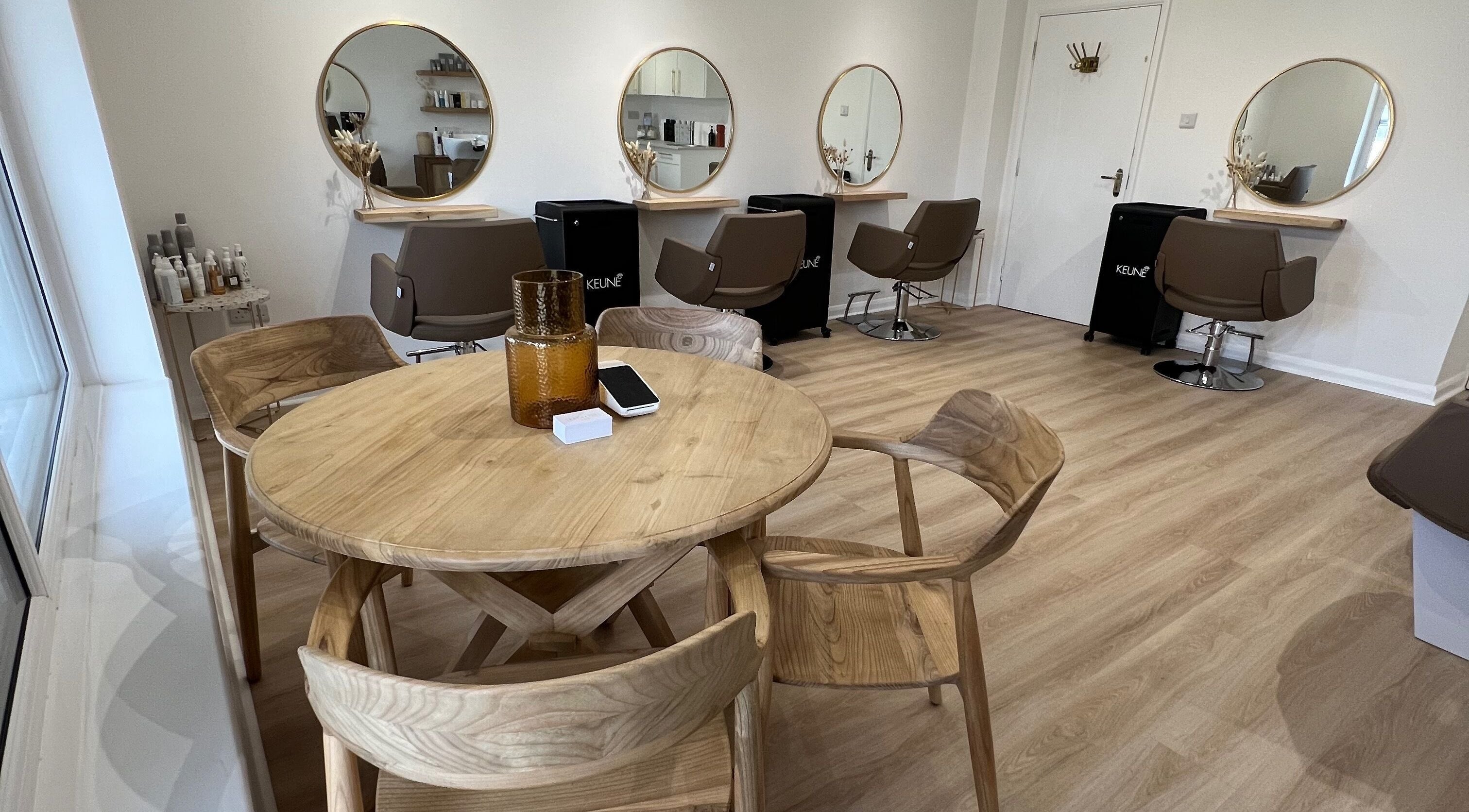 Chic interior of Esthétic Hair salon in Peacehaven, England, GB featuring modern decor and styling stations.