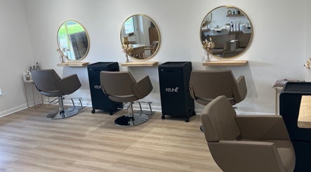 Modern salon interior at Esthétic Hair, Peacehaven, England, GB with stylish chairs and mirrors.