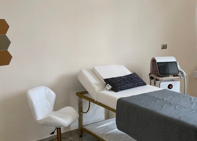 Cozy treatment room at Wellness Palace, Casablanca, Casablanca-settat, MA, featuring a white chair and massage bed.