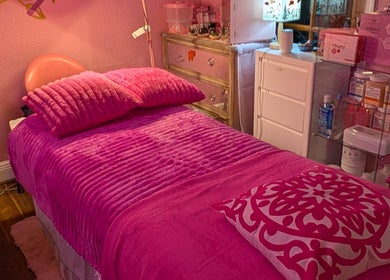 Cozy treatment room with pink bedding at Bardon Beauty, Lauderdale-by-the-sea, Florida, US.