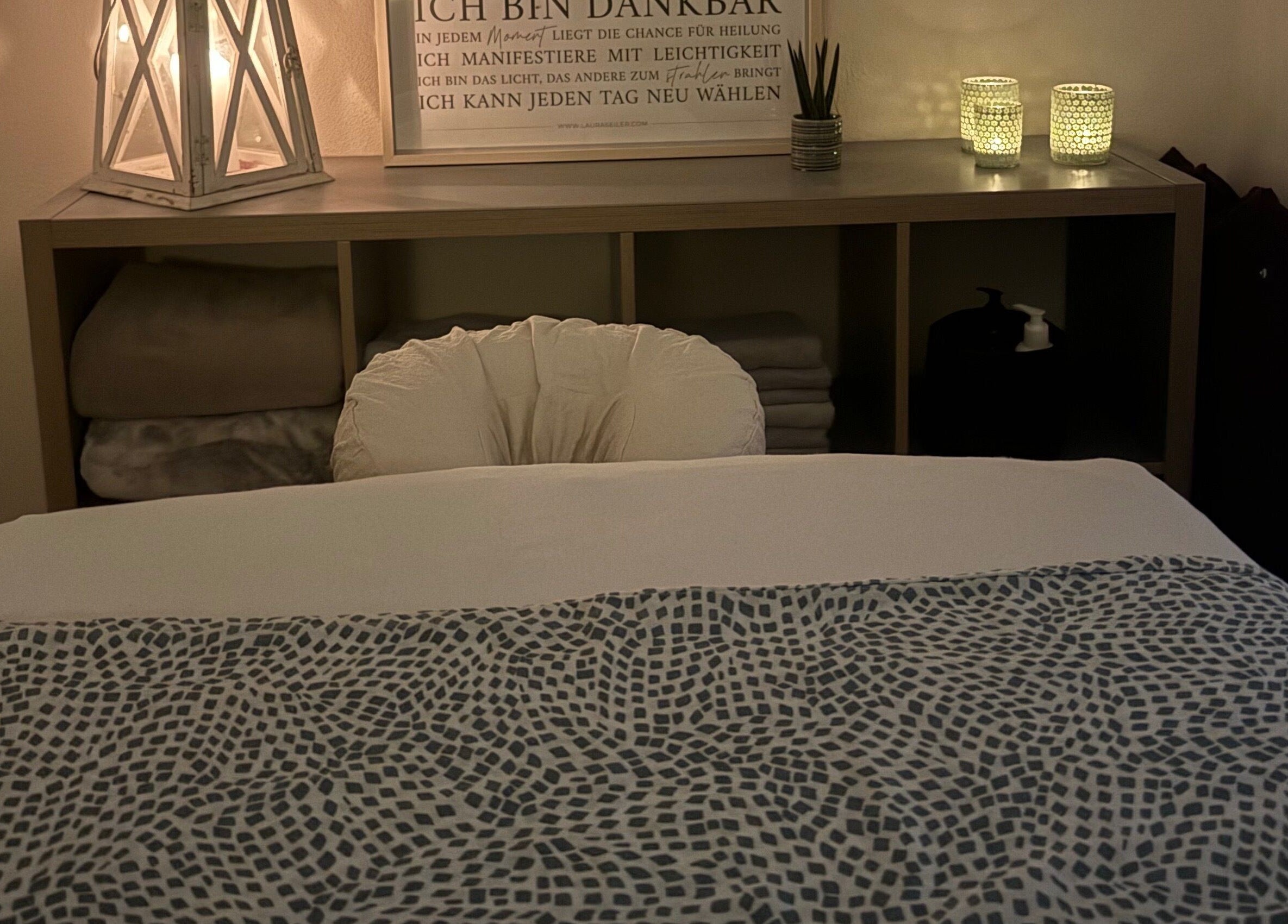 Massagebett bei Lisi de Fijter, Tandel, Kanton Vianden, LU, mit weicher Beleuchtung und dekorativen Kerzen.