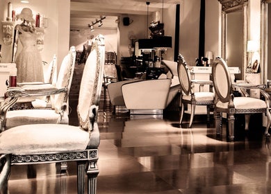 Interior elegante de Crearte Styling en Barcelona, Catalunya, ES, con sillas vintage y espejos ornamentados.