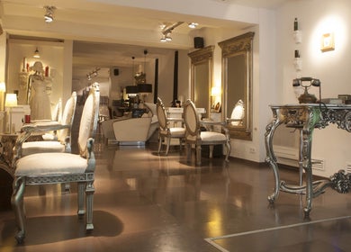 Interior elegante de Crearte Styling en Barcelona, Catalunya, ES, mostrando sillas ornamentadas y espejos dorados.