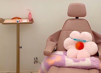 Plush floral cushion on spa chair at Opal Glow & Co., Long Beach, California, US, offering relaxing ambiance.