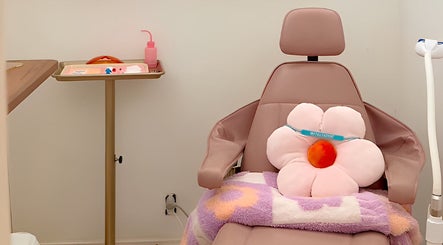 Plush floral cushion on spa chair at Opal Glow & Co., Long Beach, California, US, offering relaxing ambiance.