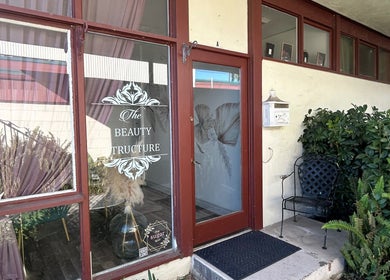 Elegant entrance of Opal Glow & Co. in Long Beach, California, US, featuring decorative glass and greenery.