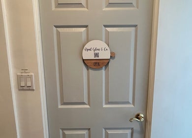 Opal Glow & Co. door sign in Long Beach, California, US. Elegant wooden design indicating open status.