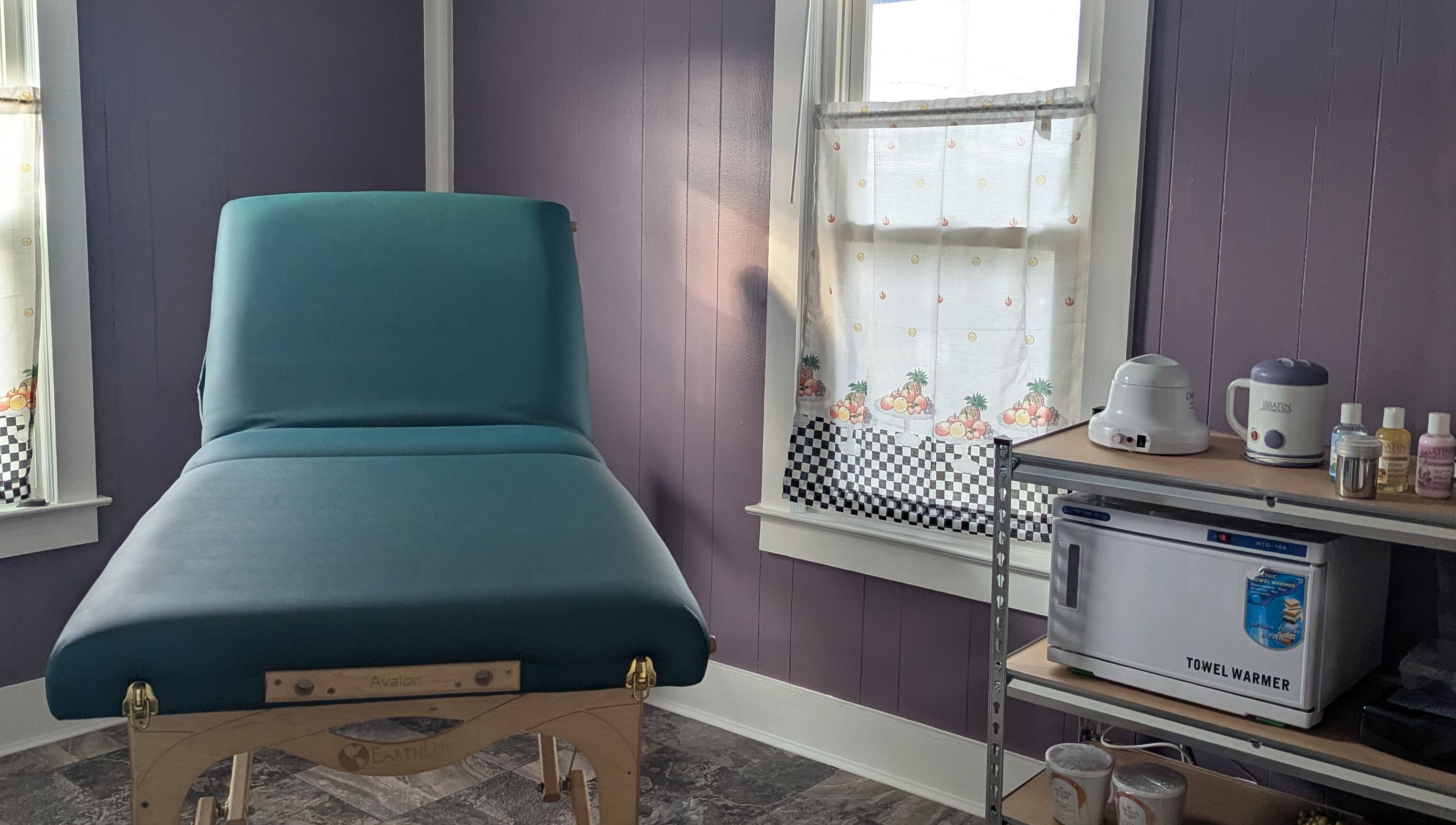 Cozy waxing room at Waxed Fruit Studio LLC, Endicott, New York, US, featuring a massage table and warming tools.