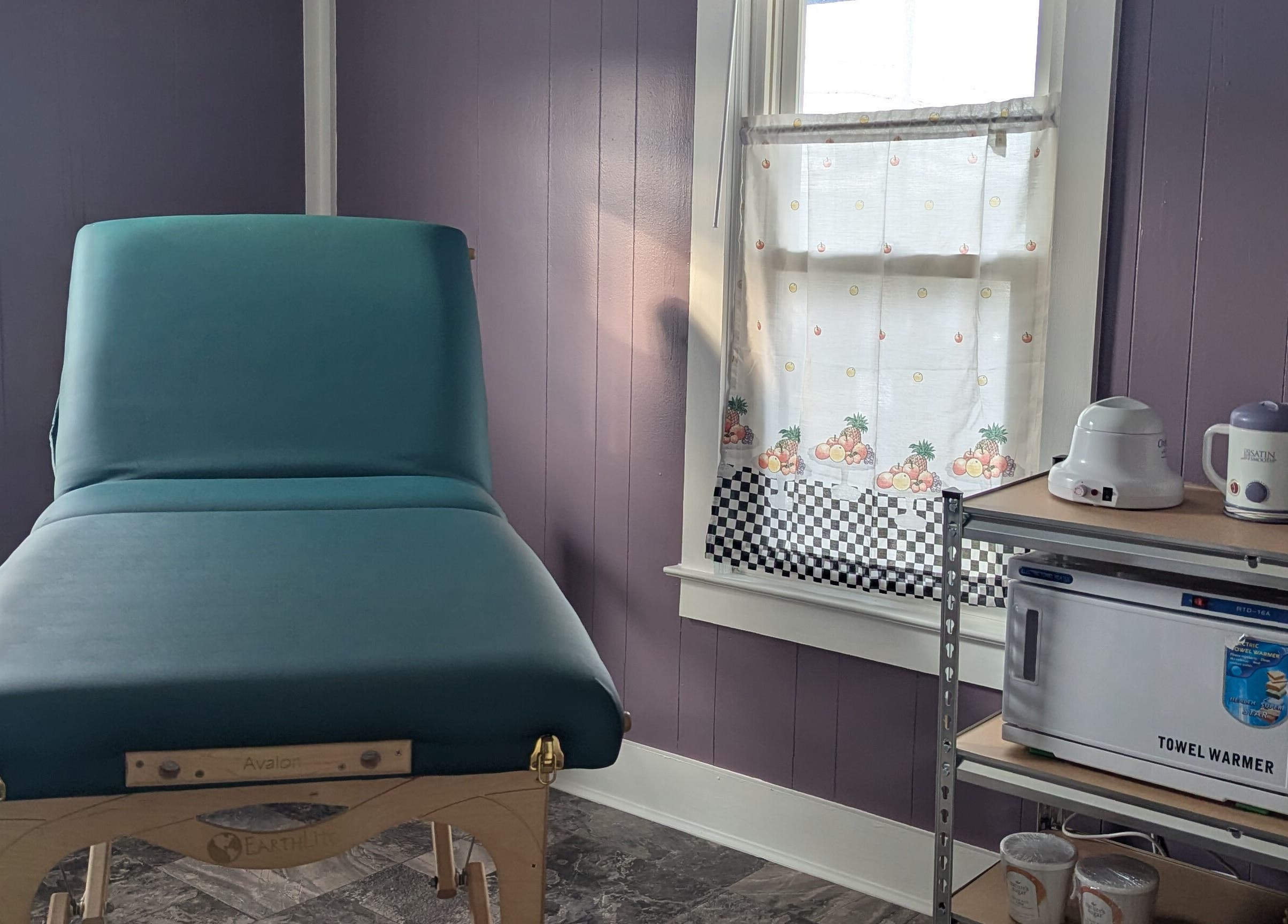 Cozy waxing room at Waxed Fruit Studio LLC, Endicott, New York, US, featuring a massage table and warming tools.