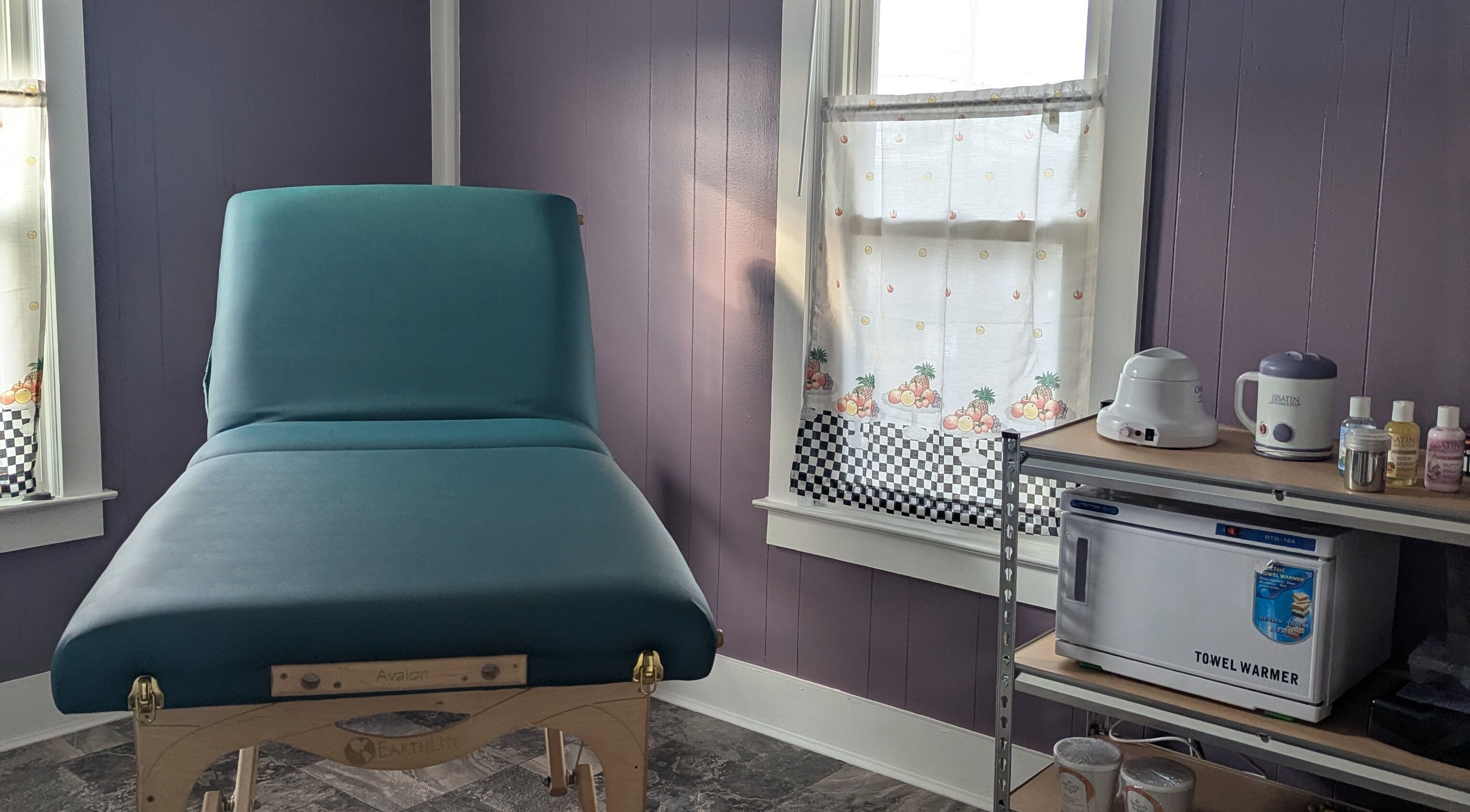 Cozy waxing room at Waxed Fruit Studio LLC, Endicott, New York, US, featuring a massage table and warming tools.