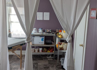 Relaxing treatment room at Waxed Fruit Studio LLC in Endicott, New York, US, featuring massage table and supplies.