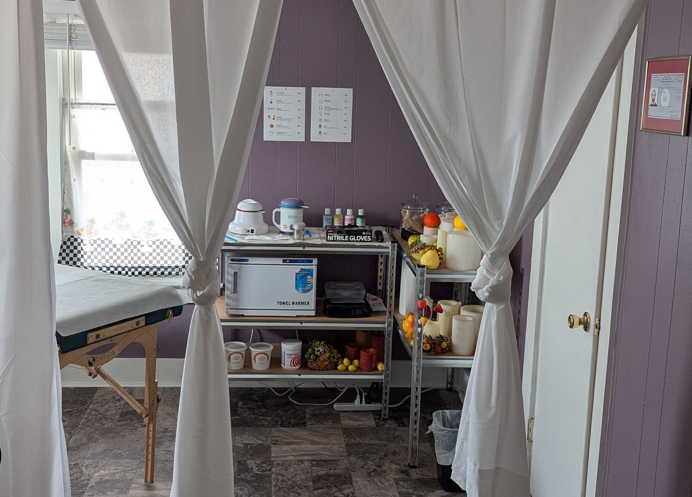 Relaxing treatment room at Waxed Fruit Studio LLC in Endicott, New York, US, featuring massage table and supplies.