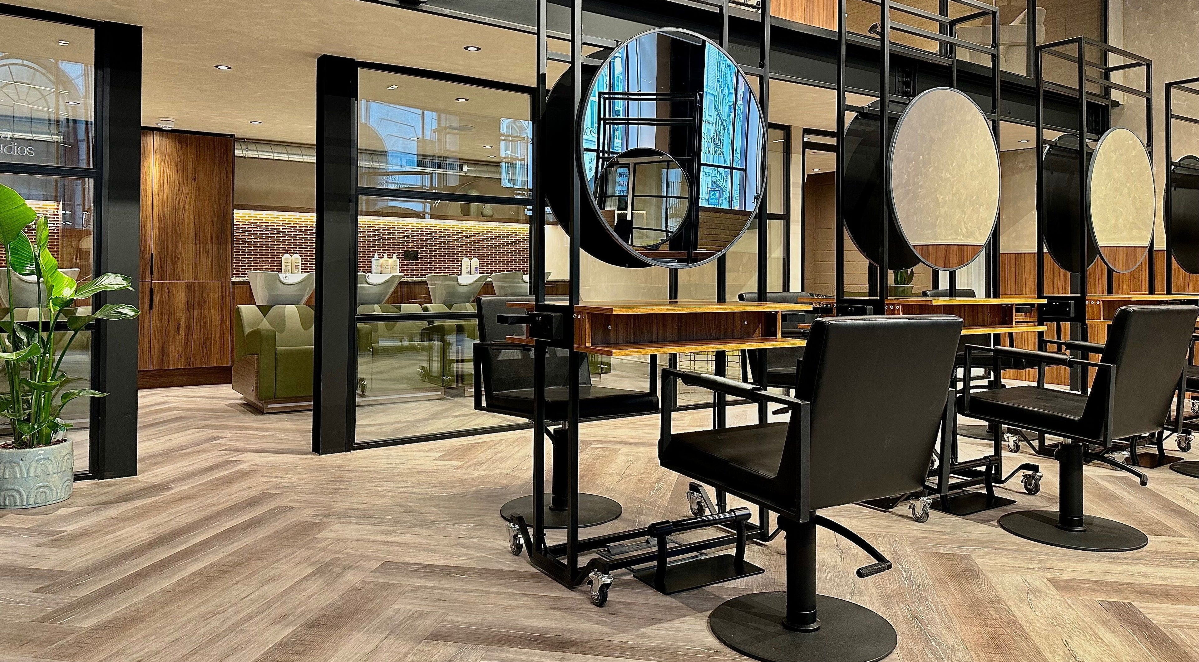Inside view of Annette Linn Hair salon in London, England. Modern design with chic mirrors and styling chairs.