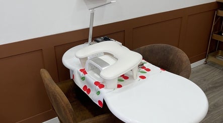 Modern nail station at ByKayleighMarie, Gateshead, England, GB with cherry-themed mat and comfortable seating.