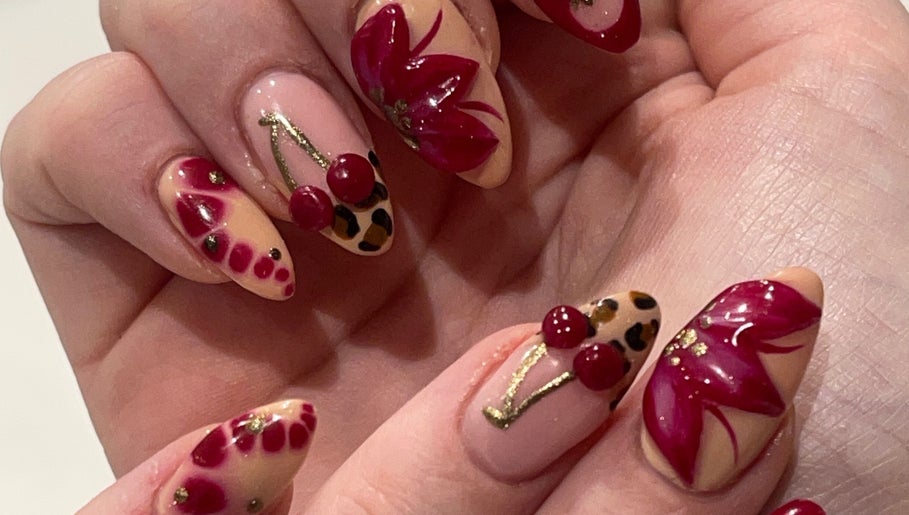 Stylish nail art with red flowers and cherries at By Kayleigh Marie, Gateshead, England, GB.