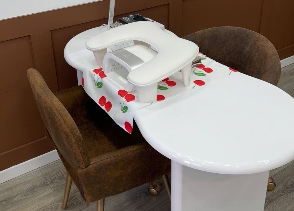 Elegant manicure station setup at 108Nails, Gateshead, England, GB, with brown chairs and a stylish table.