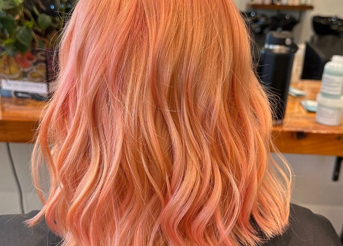 Vibrant coral hair styled in loose waves at Gracy RV, Yeerongpilly, Queensland, AU.