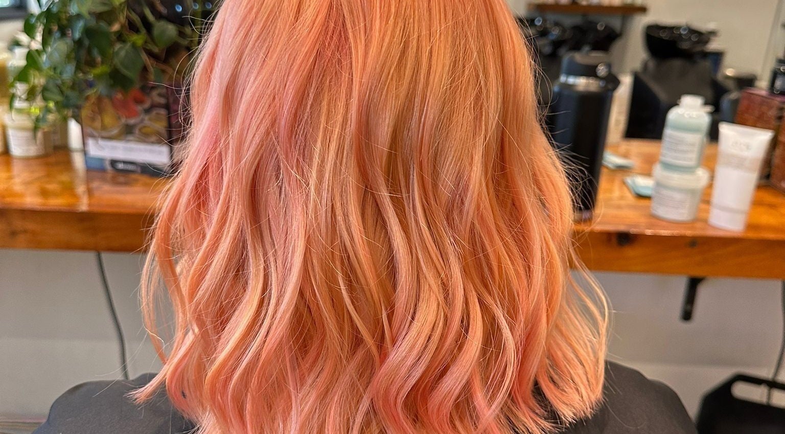 Vibrant coral hair styled in loose waves at Gracy RV, Yeerongpilly, Queensland, AU.
