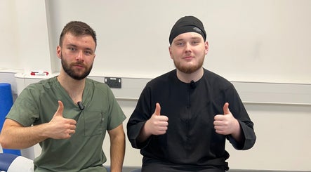 Two therapists from TruAura Mobile Massage giving thumbs up at Cardiff, Wales, GB.