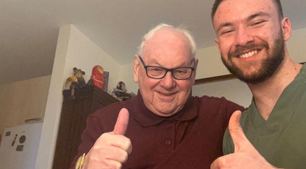 Two smiling people giving thumbs up at TruAura Mobile Massage, Cardiff, Wales, GB.
