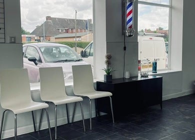 Minimalist waiting area at Eden At Jacks Barbers, Clipstone, England, GB with modern chairs and decor.