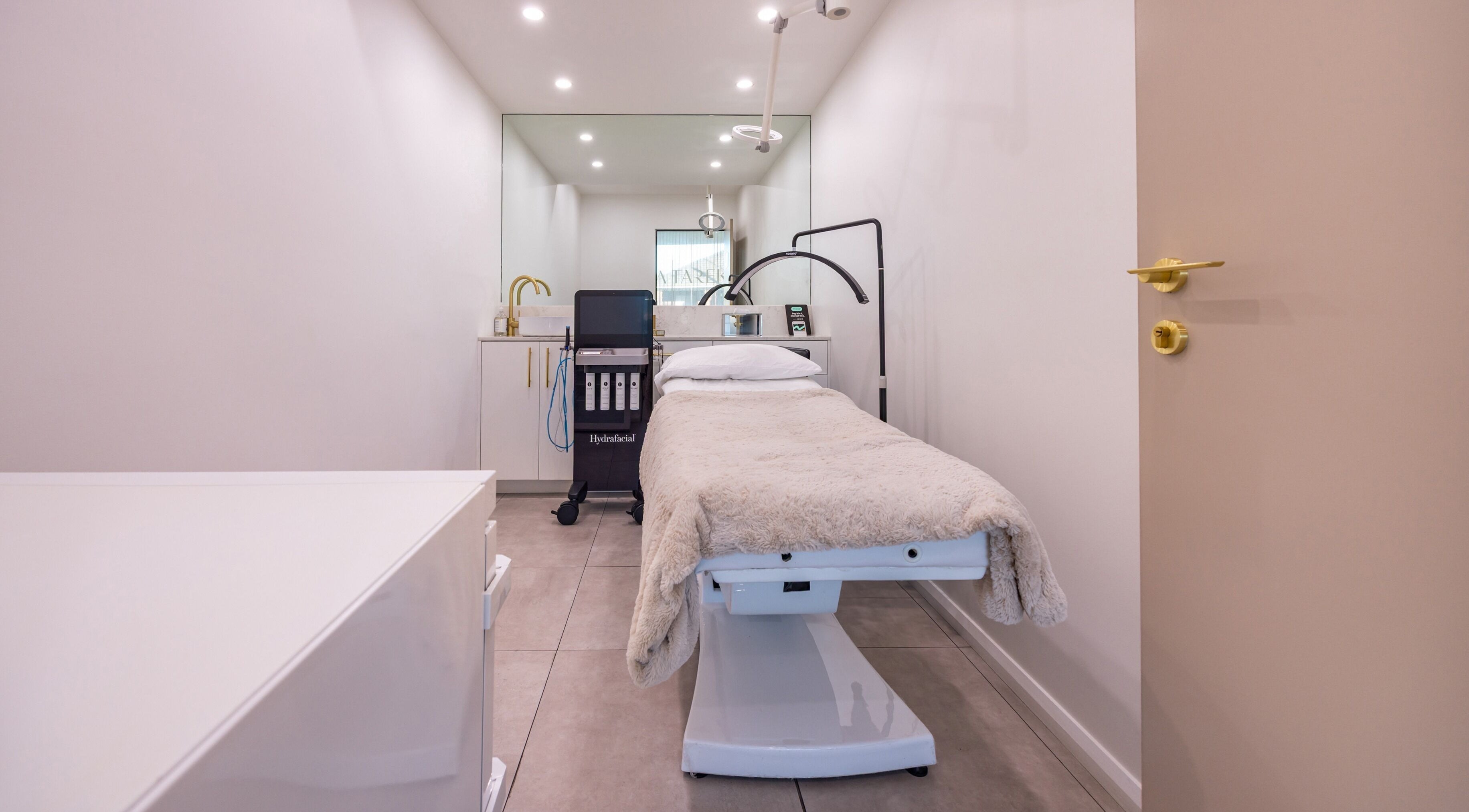 Treatment room at Lana Tarek Eyebrow Specialists, Ashfield, New South Wales, AU with a cozy bed and gold accents.